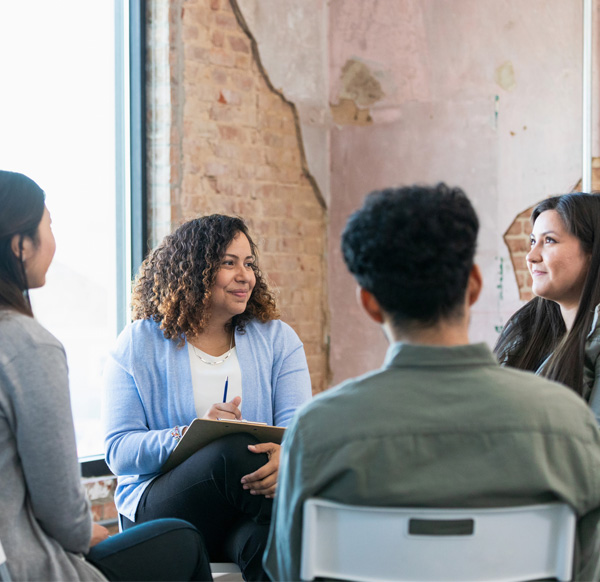 Therapy group listens attentively as young woman shares