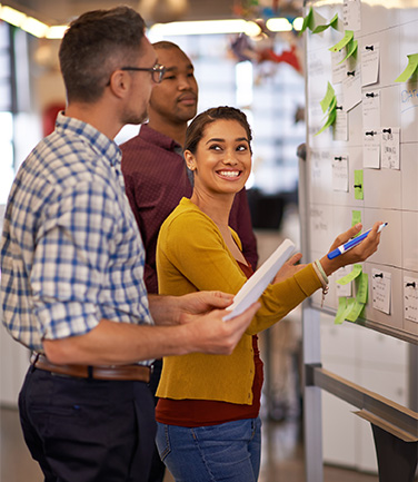 Shot of a group of coworkers brainstorming at a whiteboard