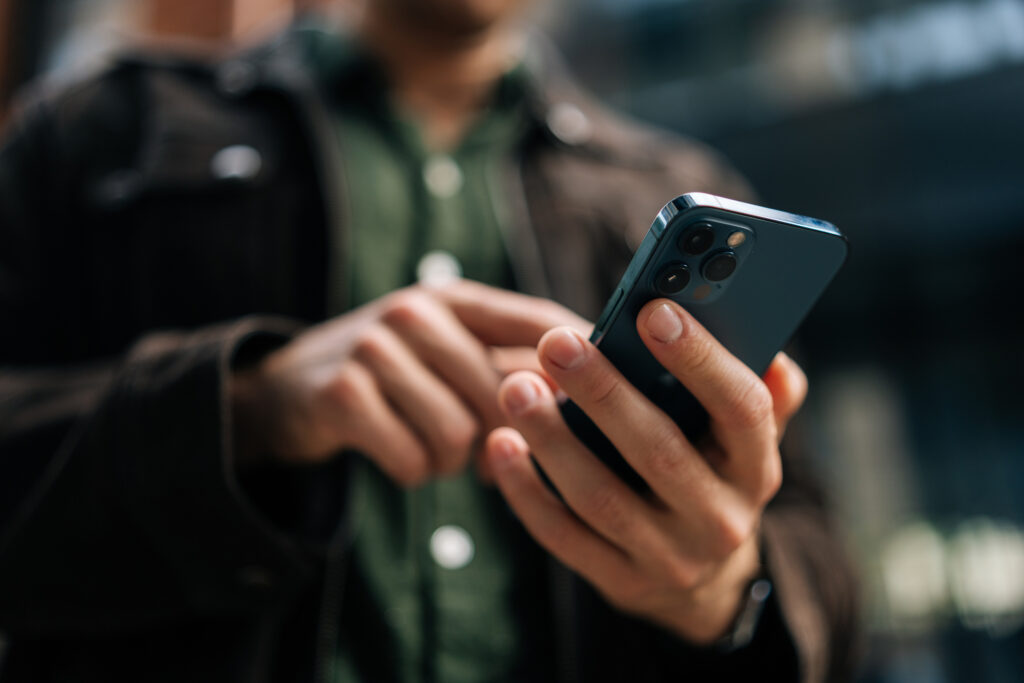 Person holding smartphone viewing Google Ads and Facebook Ads for healthcare marketing and outpatient lead generation.