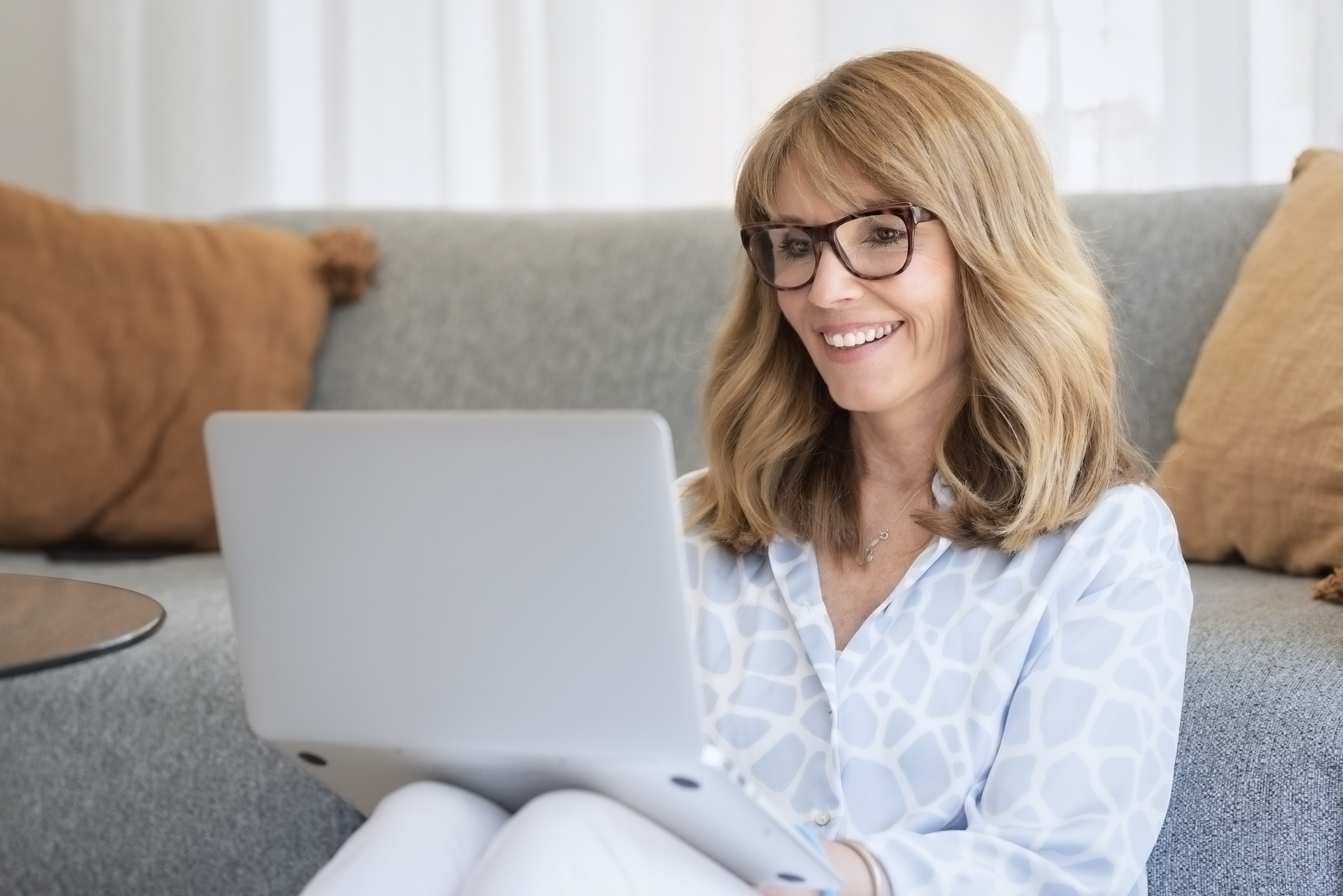 Woman addiction treatment center owner researching healthcare advertising agencies on her laptop.