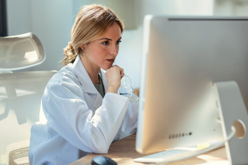 Clinical director at addiction treatment center reviewing PPC campaign performance on her computer from a specialized PPC expert