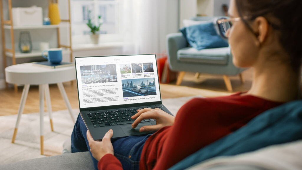 Young woman at home reading an online article on her laptop that features native advertising content designed to educate healthcare audiences.