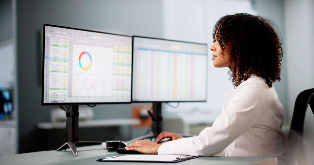 Woman reflecting on improvements in healthcare lead capture as she gazes at her computer screens