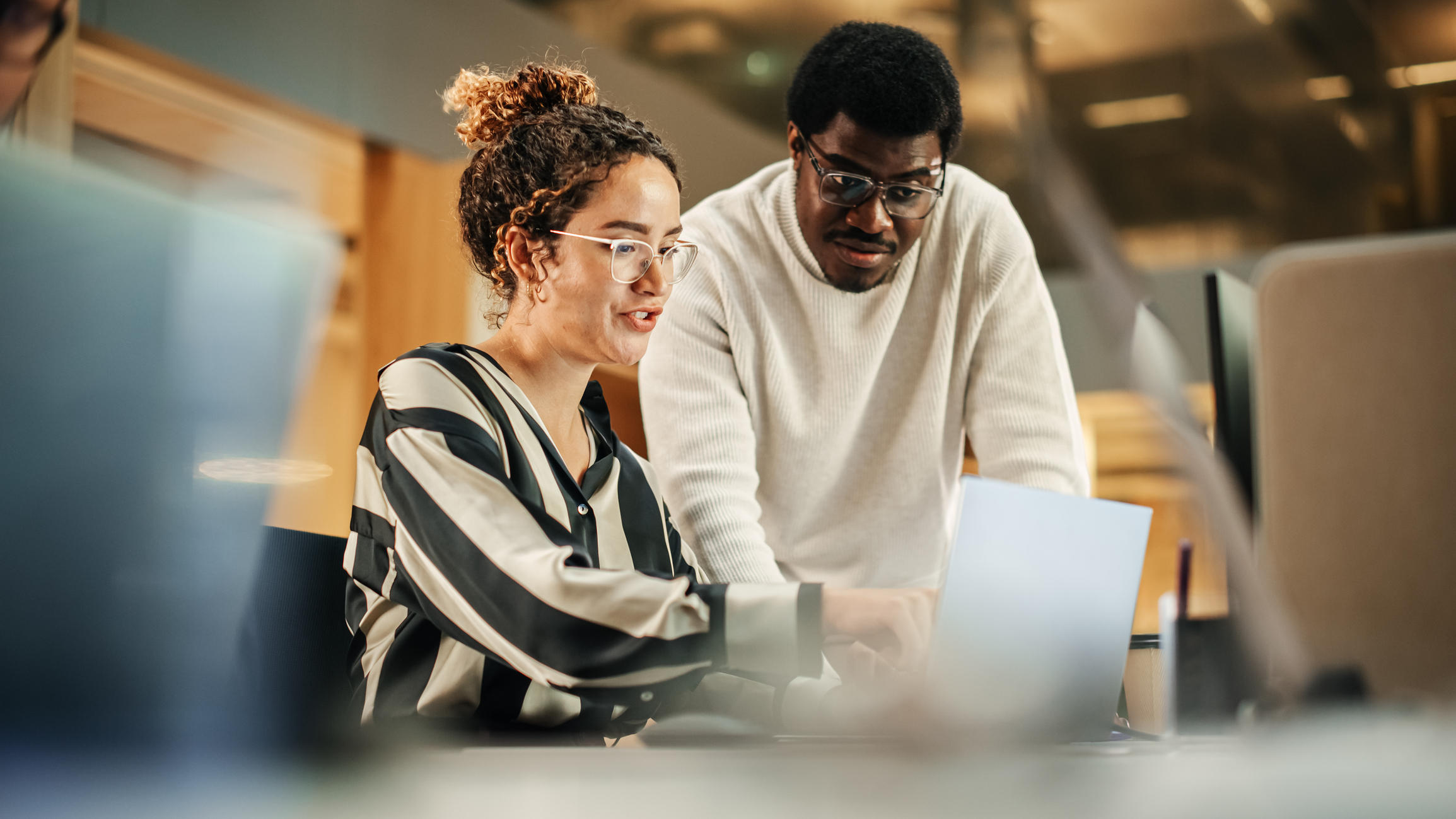Two colleagues analyzing campaign results on a laptop to identify ppc audience mismatch issues