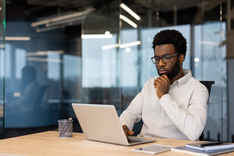Business professional reviewing Google Ads lead data and CRM records on a laptop.