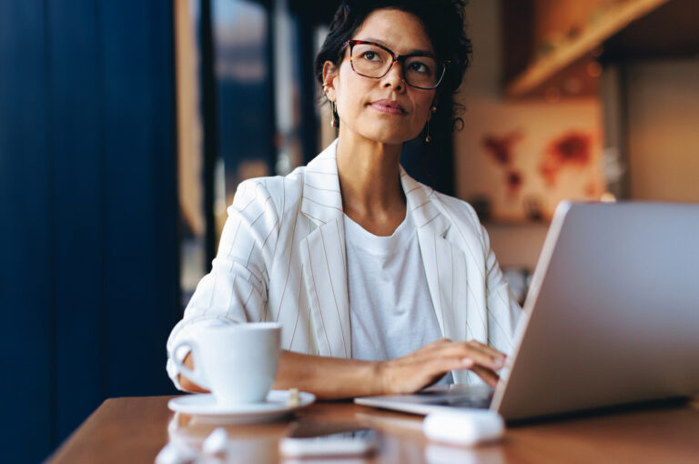 Business professional reviewing advertising performance on a laptop to determine whether her cost per lead is too high.